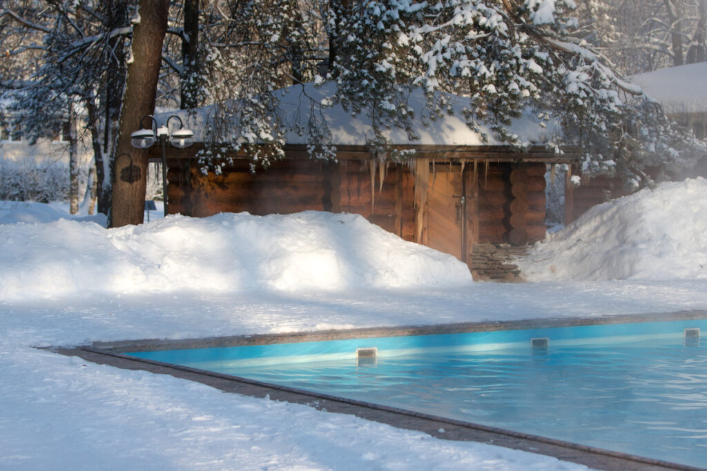 Swimming pool surrounded by piles of snow in the winter