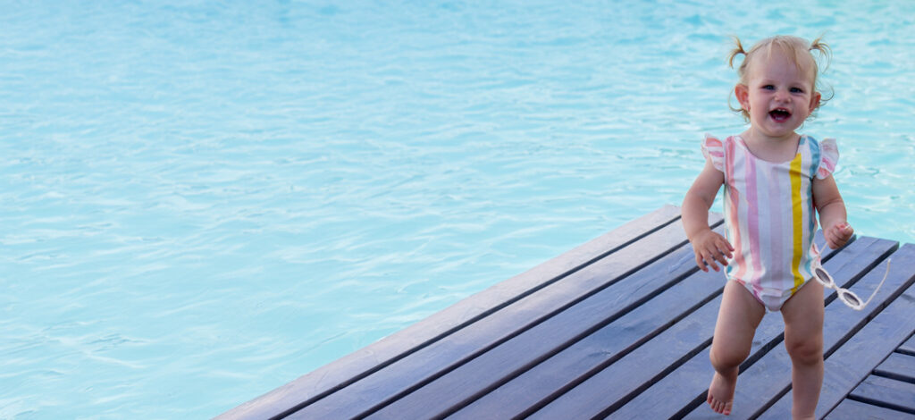 Little girl plays on pool deck